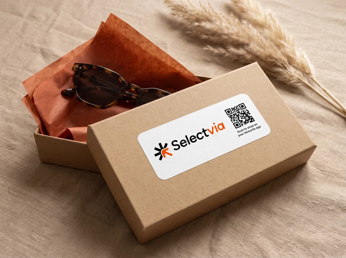 A kraft mailer box with sunglasses and a Selectvia sticker with a QR code: scan to shop on your favourite app